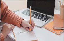 Student writing on a notepad