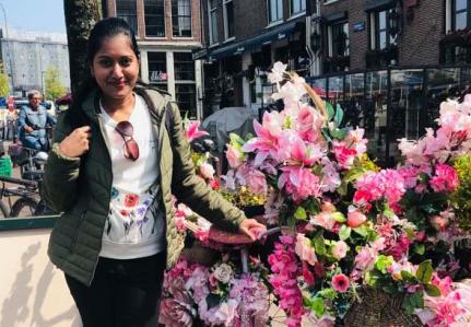 Nipuni standing next to a bike covered in flowers